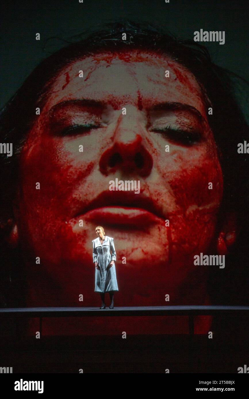 Sarah Tynan (as Lucia in Lucia di Lammermoor by Donizetti) with Marina Abramovic (as Maria Callas in film sequence) in 7 DEATHS OF MARIA CALLAS at English National Opera (ENO), London Coliseum, London WC2  03/11/2023  with music by Marko Nikodijevic  libretto: Petter Skavlan & Marina Abramovic   conductor: Yoel Gamzou  design: Marina Abramovic & Anna Schoetl  costumes: Riccardo Tisci for Burberry  lighting: Urs Schoenebaum  film director: Nabil Elderkin  visual intermezzos: Marco Brambilla  stage director: Marina Abramovic  NB: image shot through a gauze screen used for film projection Stock Photo