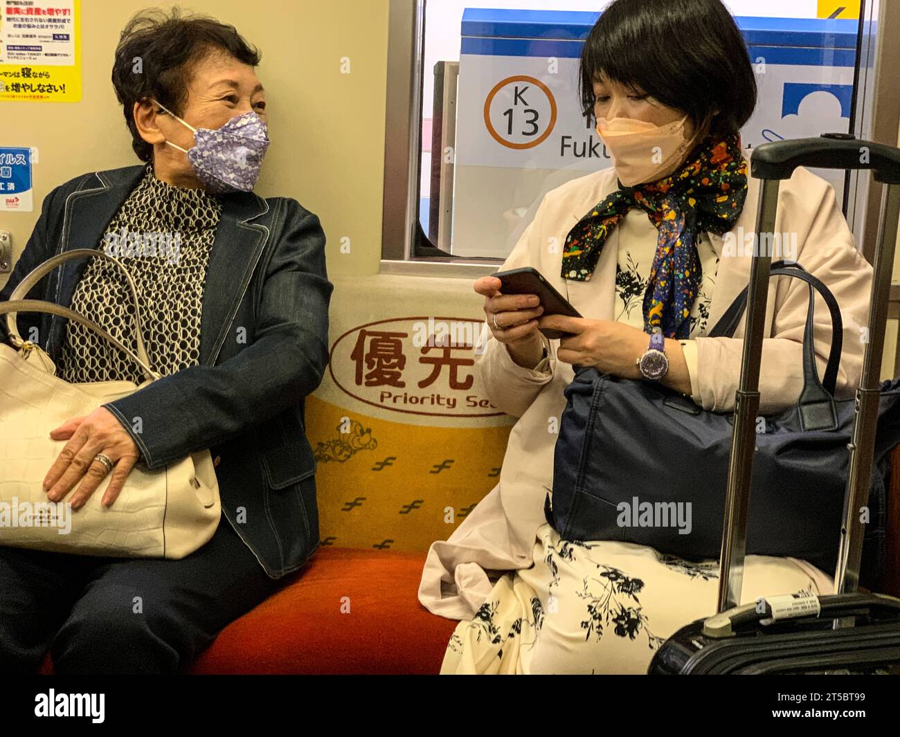 Fukuoka, Japan. Two Middle-aged Japanese Wopmen on Train from Airport to Hakata Station. Stock Photo