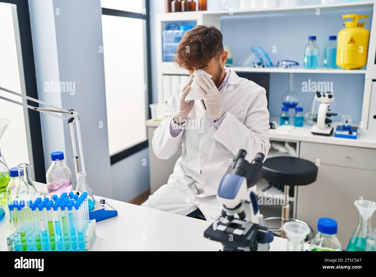 Young arab man scientist using napkin at laboratory Stock Photo