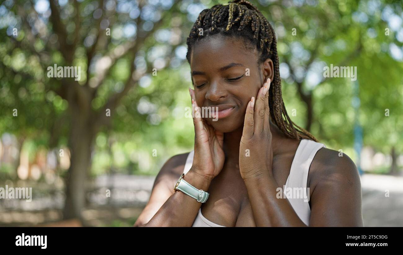 African american woman smiling confident touching face at park Stock ...