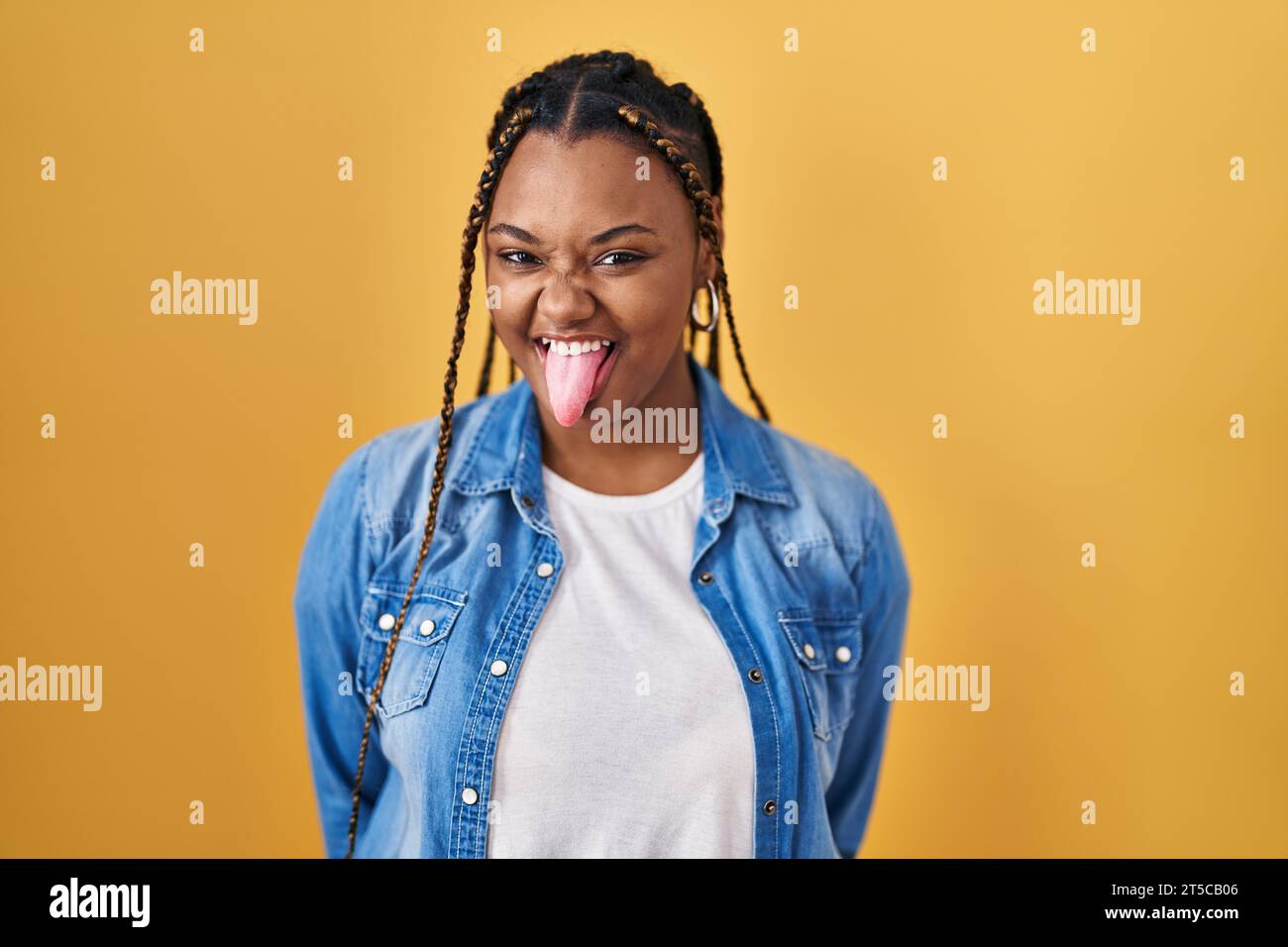 African american woman with braids standing over yellow background ...