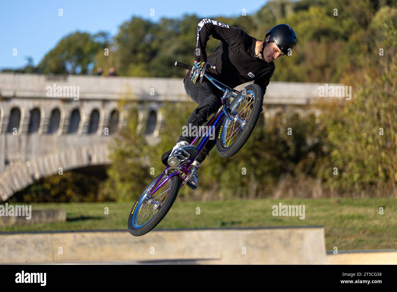 Young man performing acrobatics on a bmx bike in a skatepark, Agen, France Stock Photo