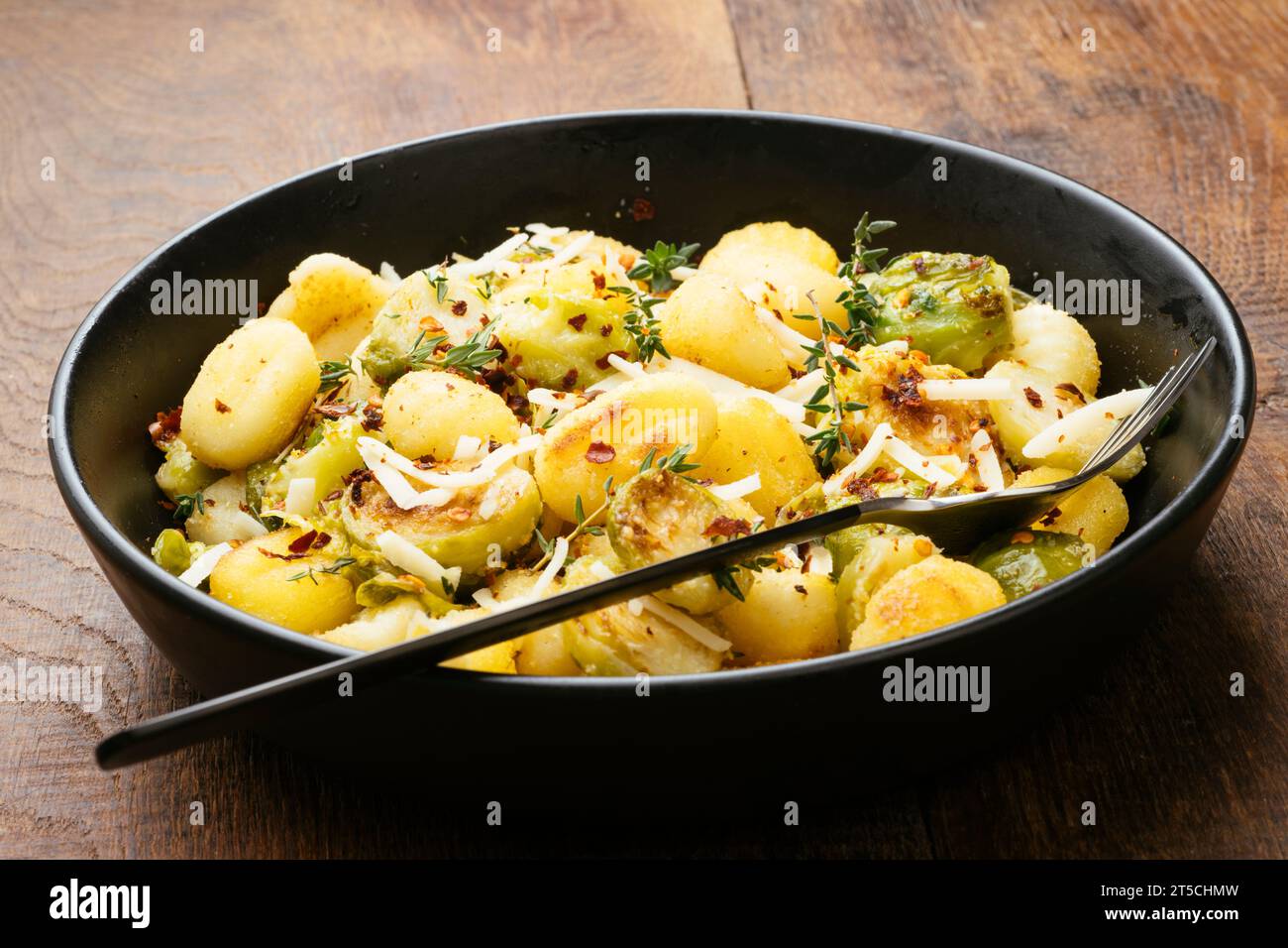 Roasted gnocchi and Brussels sprouts skillet with shredded vegan cheese