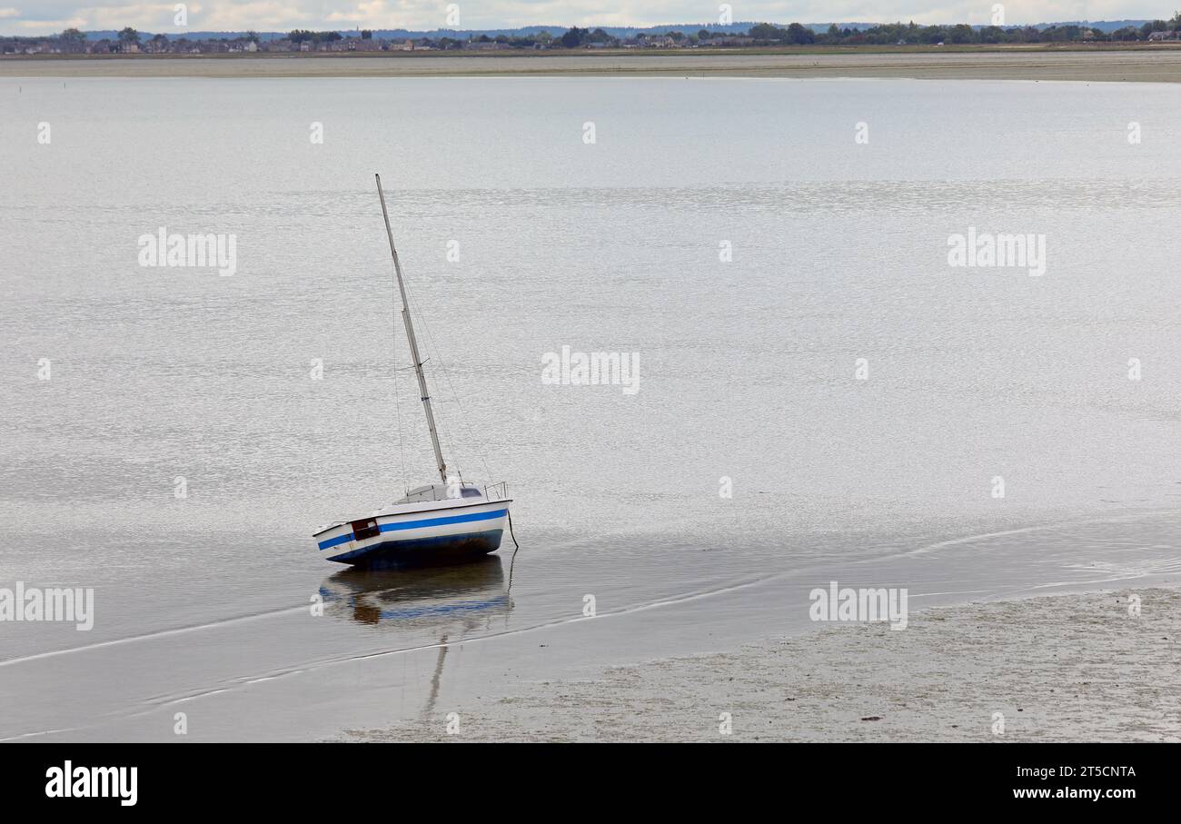 Stranded boat on the seabed during low tide in the town Cancale in ...