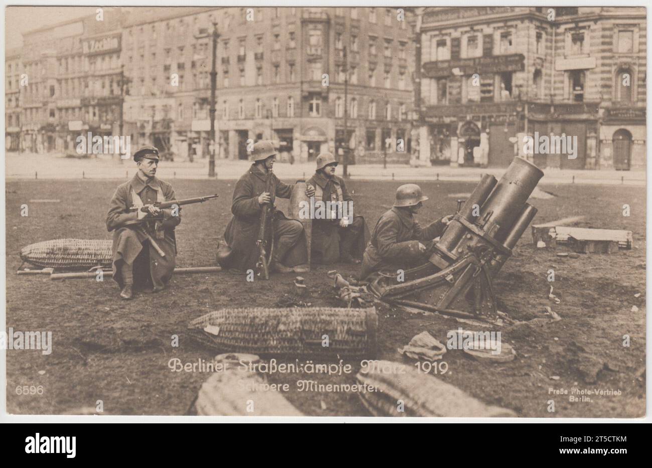 'Berliner straßenkämpfe, März 1919. Schwere Minenwerfer' / 'Berlin street fighting, March 1919. Heavy mortars'. Four German soldiers on a grassed area by a Berlin street, three have rifles, one is operating a large mortar. Shells are on the grass around them, in wicker covers. The photograph shows street fighting during the 1919 March Battles in Berlin Stock Photo