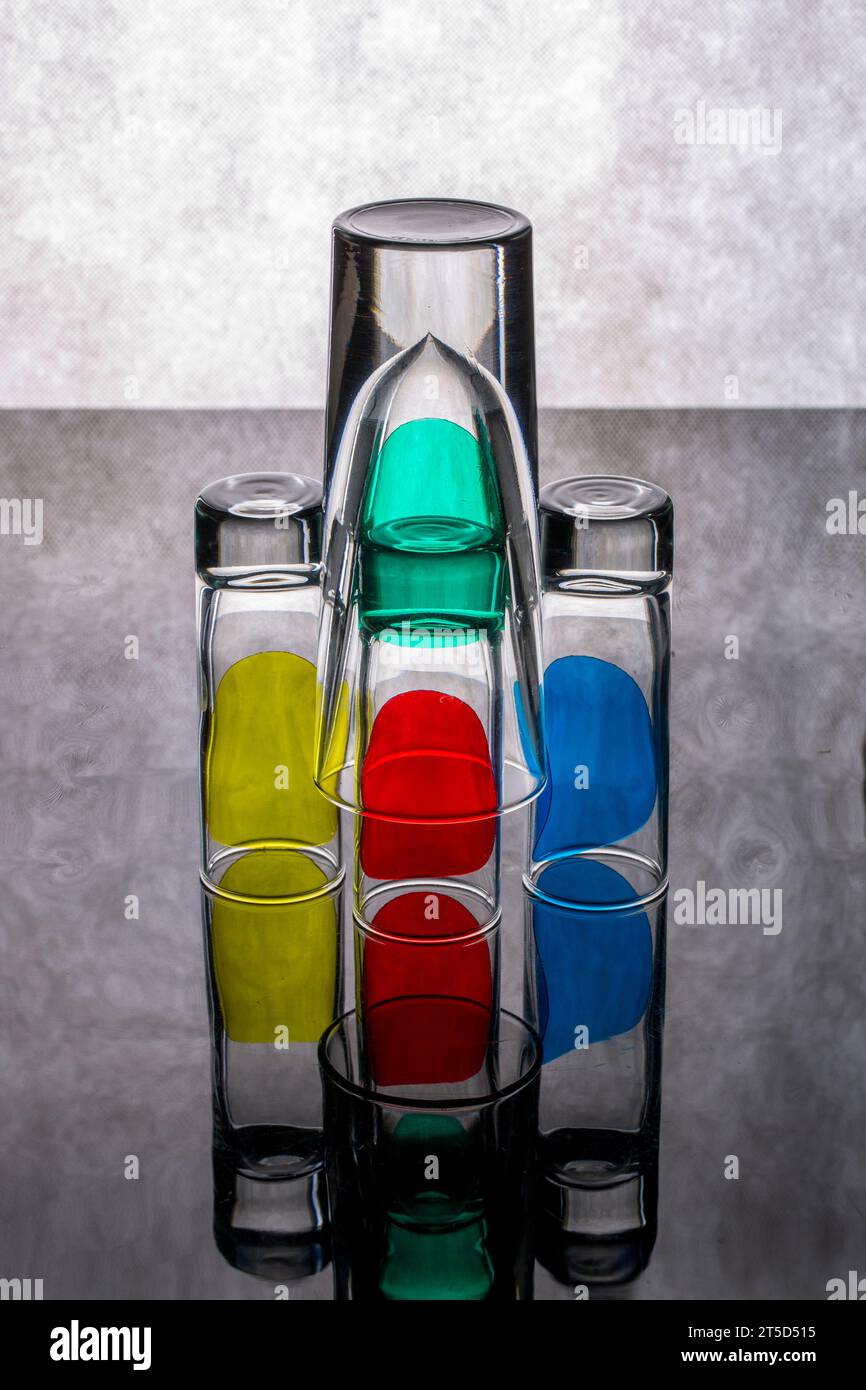 Still life with glass objects with colored spots on a reflective ...