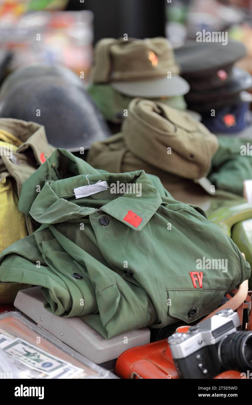 012 Vintage green fatigues shirt, field hats, peaked caps, helmets, of the voluntary military pro-Chinese communist forces. Tirana-Albania. Stock Photo
