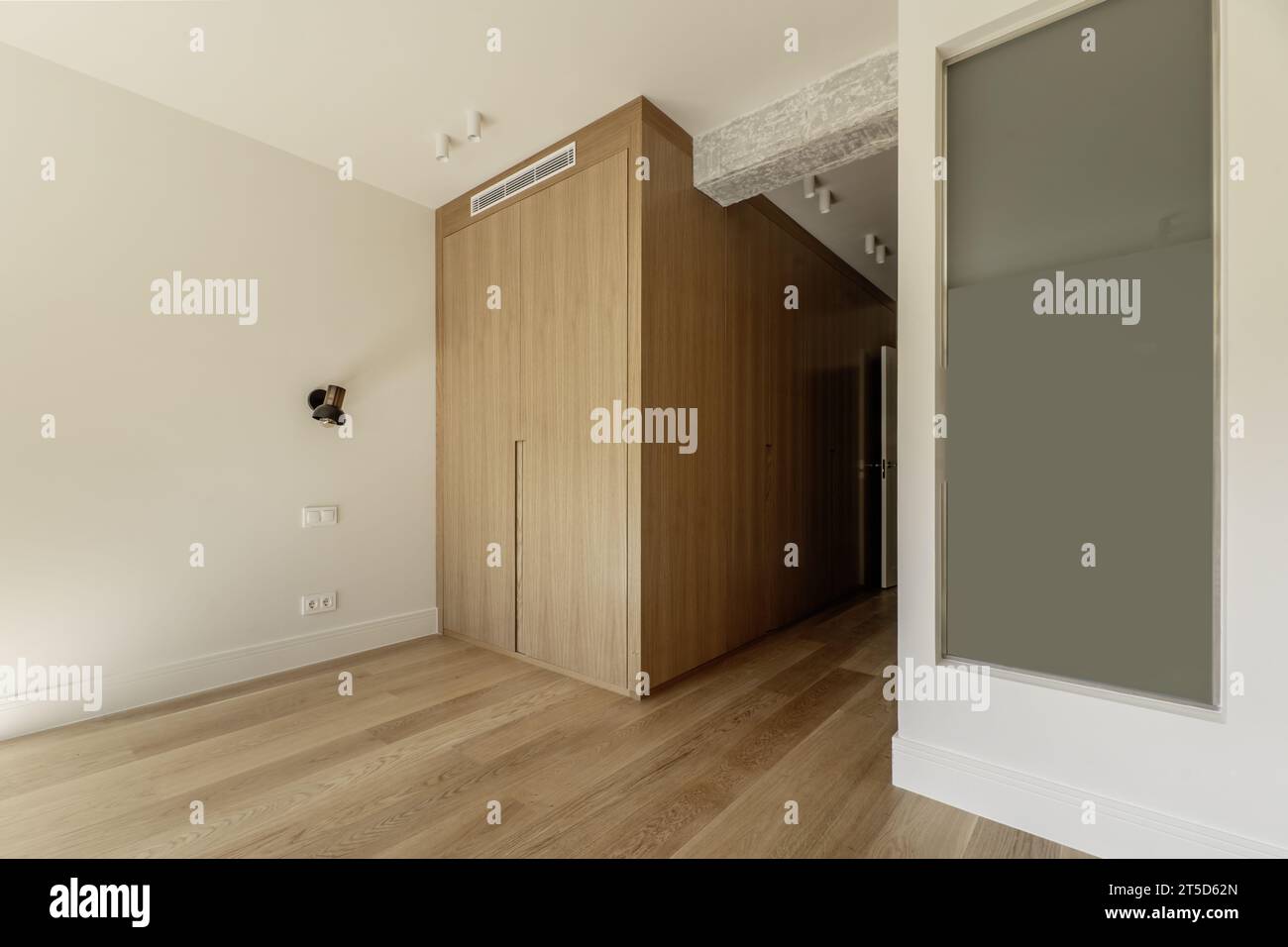 Beautiful contemporary designed room with custom wardrobe with oak doors, skylight to the en-suite bathroom Stock Photo