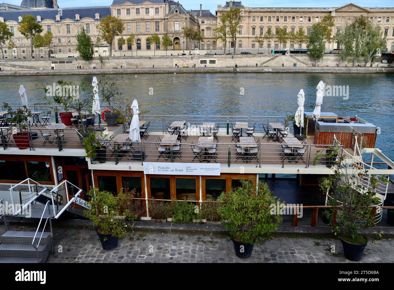 Peniche la Balle ou Bond floating restaurant on Seine river with Louvre Museum on opposite shore in Paris, France Stock Photo