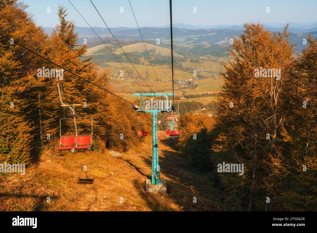 This captivating photo features an old cable car nestled in the backdrop of picturesque autumn mountains, basking in the warm glow of a sunny day. It Stock Photo