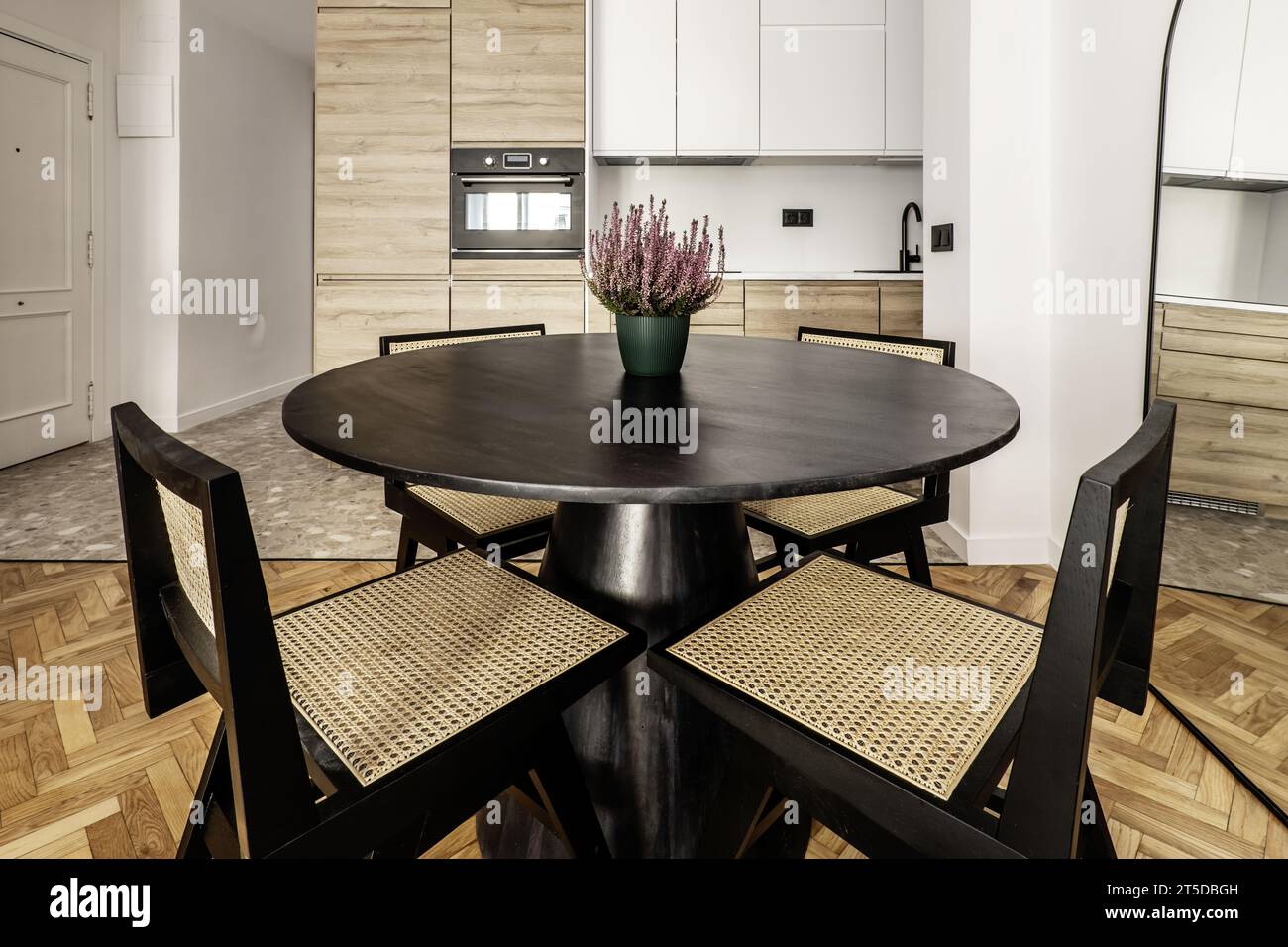 Round black wooden dining table with matching black chairs Stock Photo