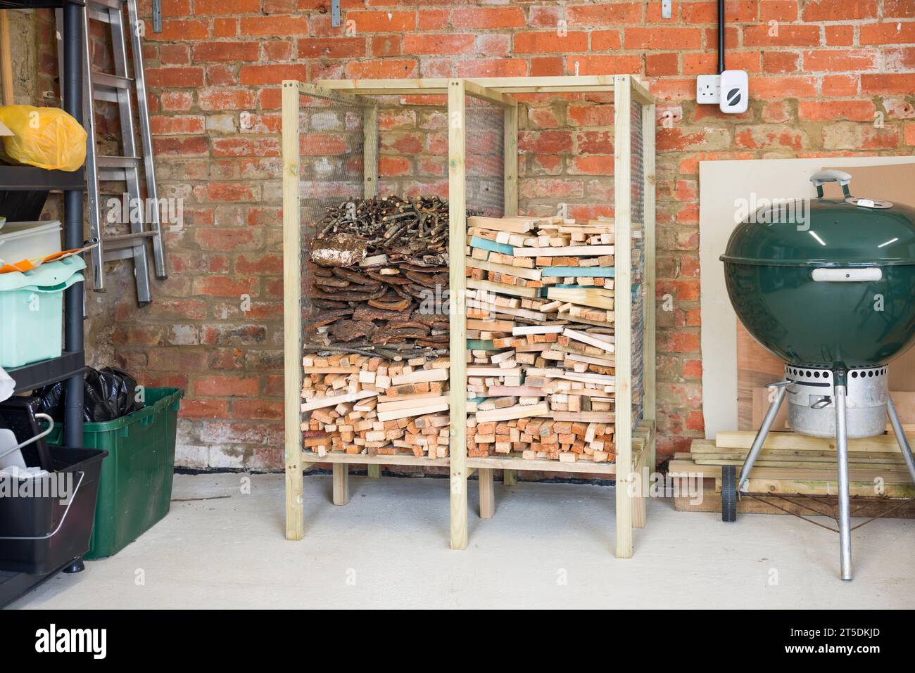 Wooden rack for storing kindling, kindling storage inside a garage, UK Stock Photo
