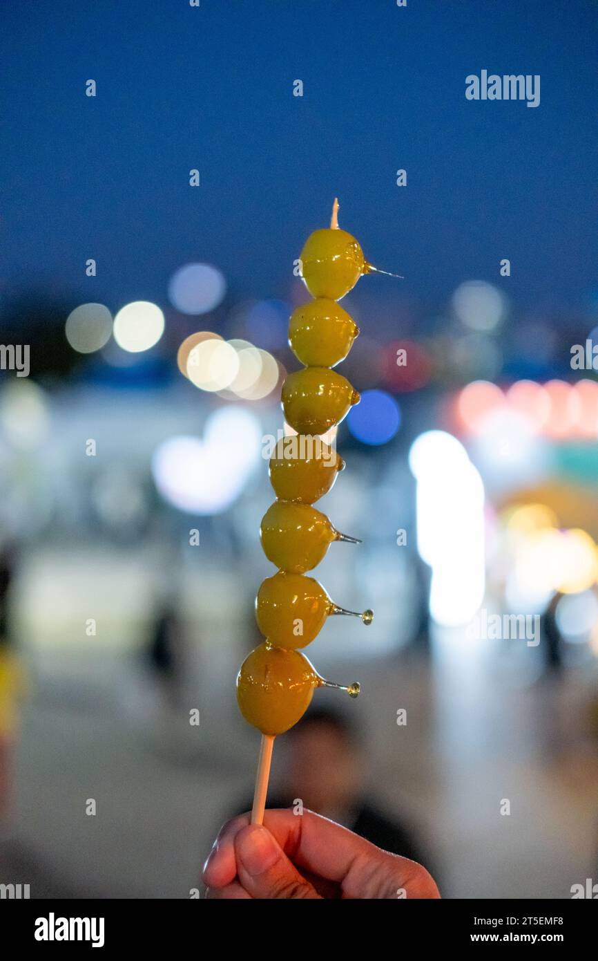 Muscat grape Tanghulu or Tang Hulu. It is a grape dipped with sugar coating on a skewer. It is a traditional Northern Chinese snack. Stock Photo