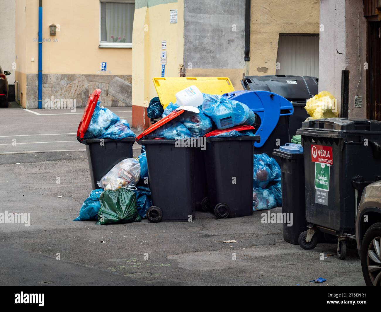 Overflowing trash cans on the street. Garbage everywhere in an urban
