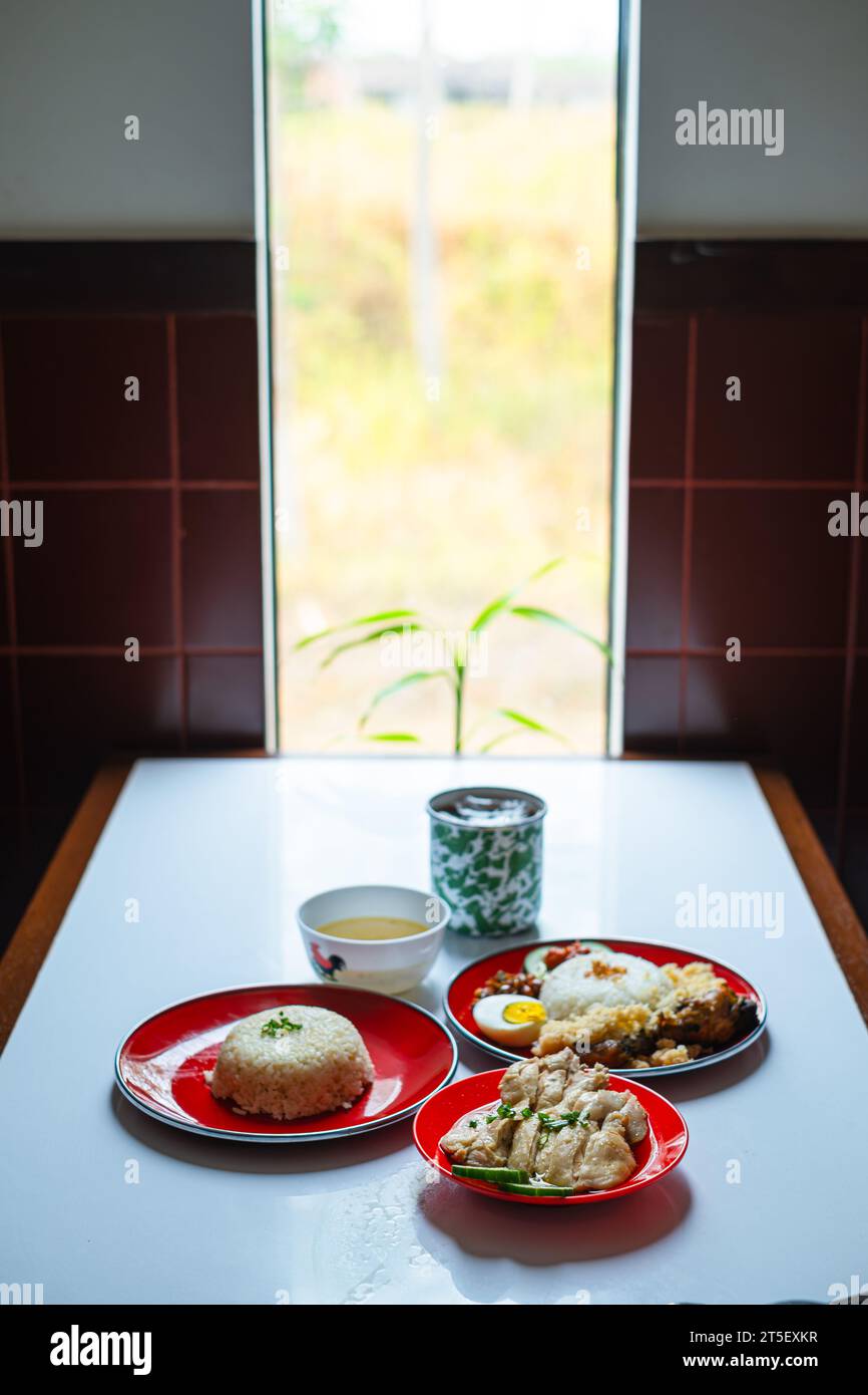 A menu set of Malaysian typical dish or food. Nasi Hainan, Nasi Lemak, and a cup of coffee. Portrait or vertical. Stock Photo