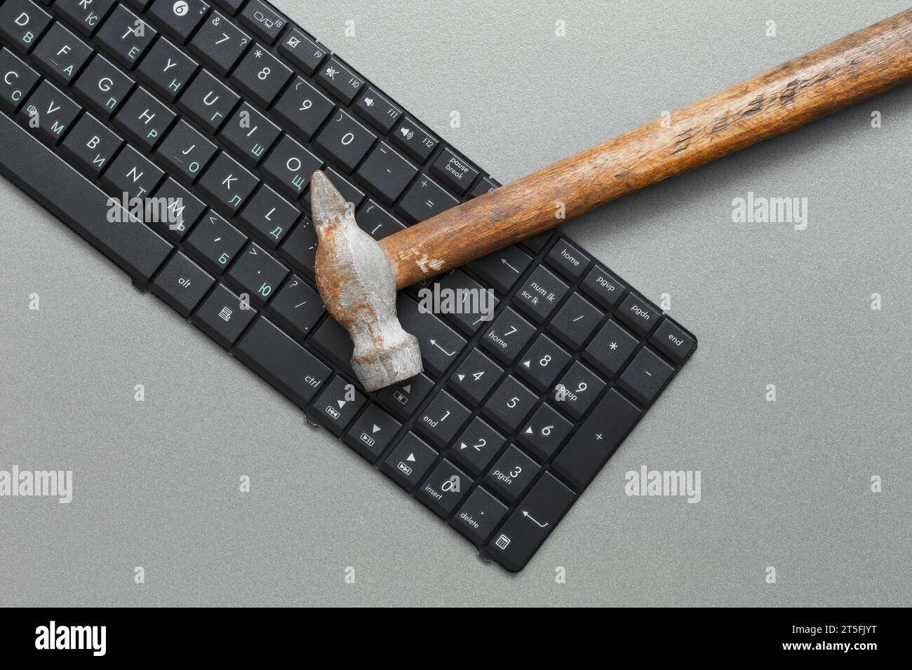 Computer keyboard and hammer.Concept for maintenance and repair of computer equipment. Stock Photo
