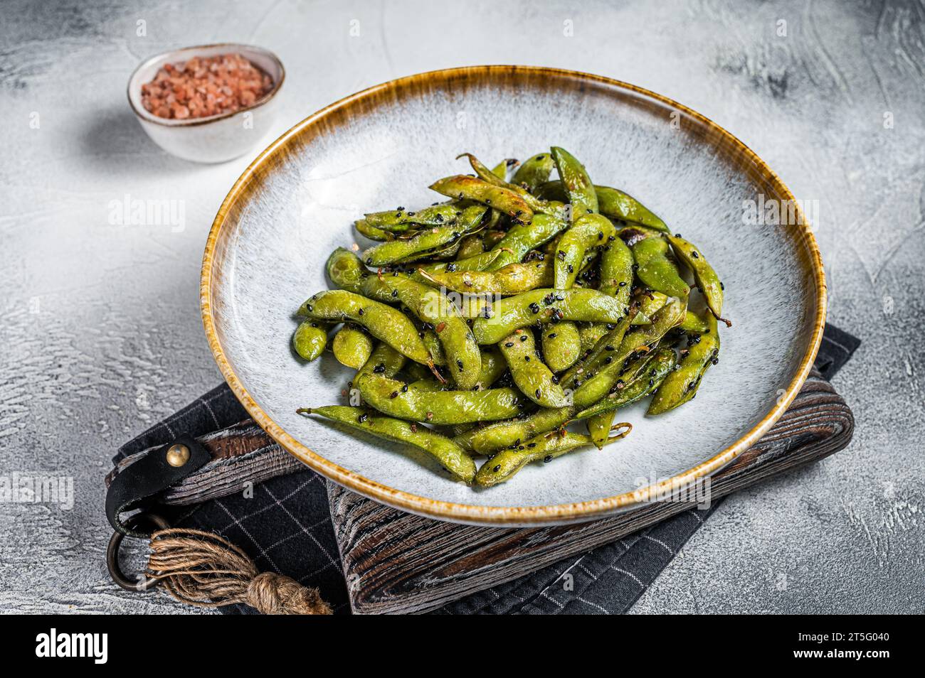 Spicy grilled Edamame Soy Beans with sea salt in a plate. White