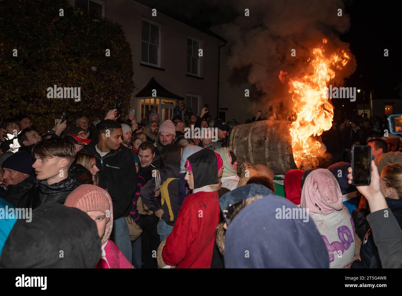 Ottery St Mary, UK. Saturday 4 November 2023. Locals take part in the Ottery St Mary Burning Tar Barrels. Running with burning barrels through the streets of Ottery St Mary in Devon in a traditional event stretching back hundreds of years. Credit: Thomas Faull/Alamy Live News Stock Photo
