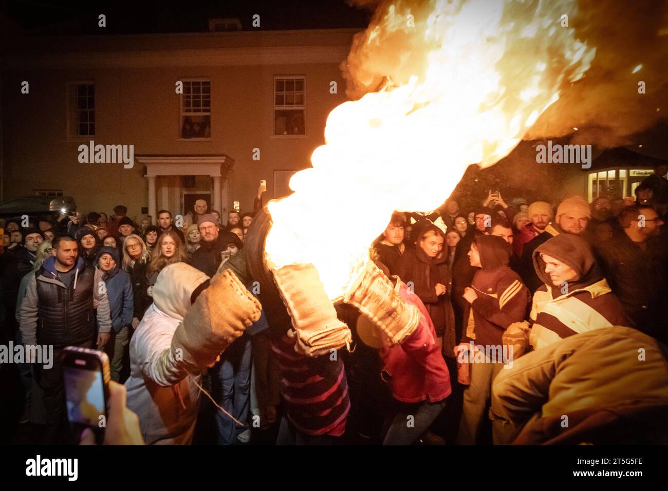 Ottery St Mary, UK. Saturday 4 November 2023. Locals take part in the Ottery St Mary Burning Tar Barrels. Running with burning barrels through the streets of Ottery St Mary in Devon in a traditional event stretching back hundreds of years. Credit: Thomas Faull/Alamy Live News Stock Photo