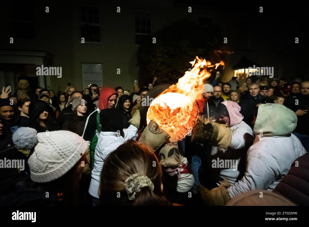 Ottery St Mary, UK. Saturday 4 November 2023. Locals take part in the Ottery St Mary Burning Tar Barrels. Running with burning barrels through the streets of Ottery St Mary in Devon in a traditional event stretching back hundreds of years. Credit: Thomas Faull/Alamy Live News Stock Photo