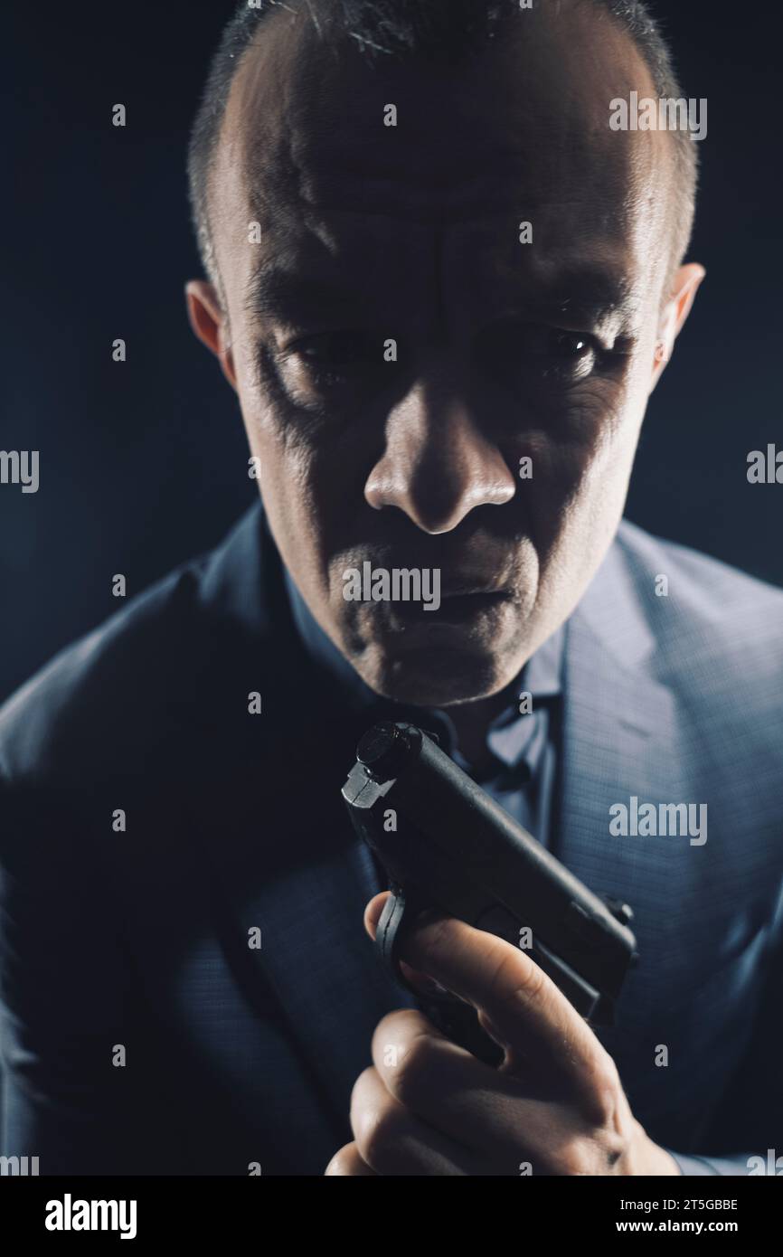 Assasin spy killer with handgun pistol in elegant suit and shirt book thriller cover deign. Stock Photo