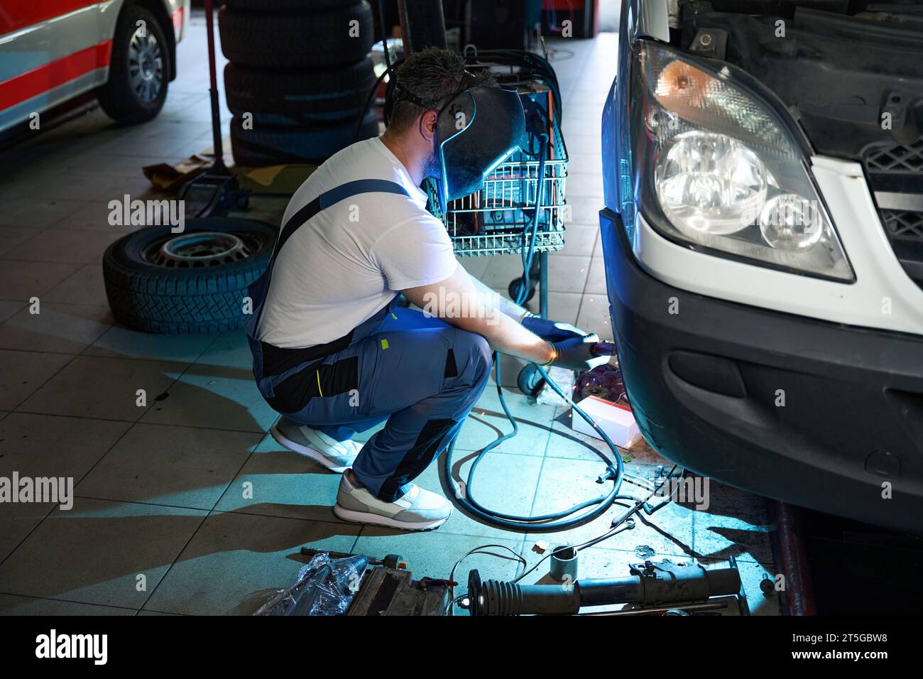 Experienced automotive service technician is repairing customer van Stock Photo