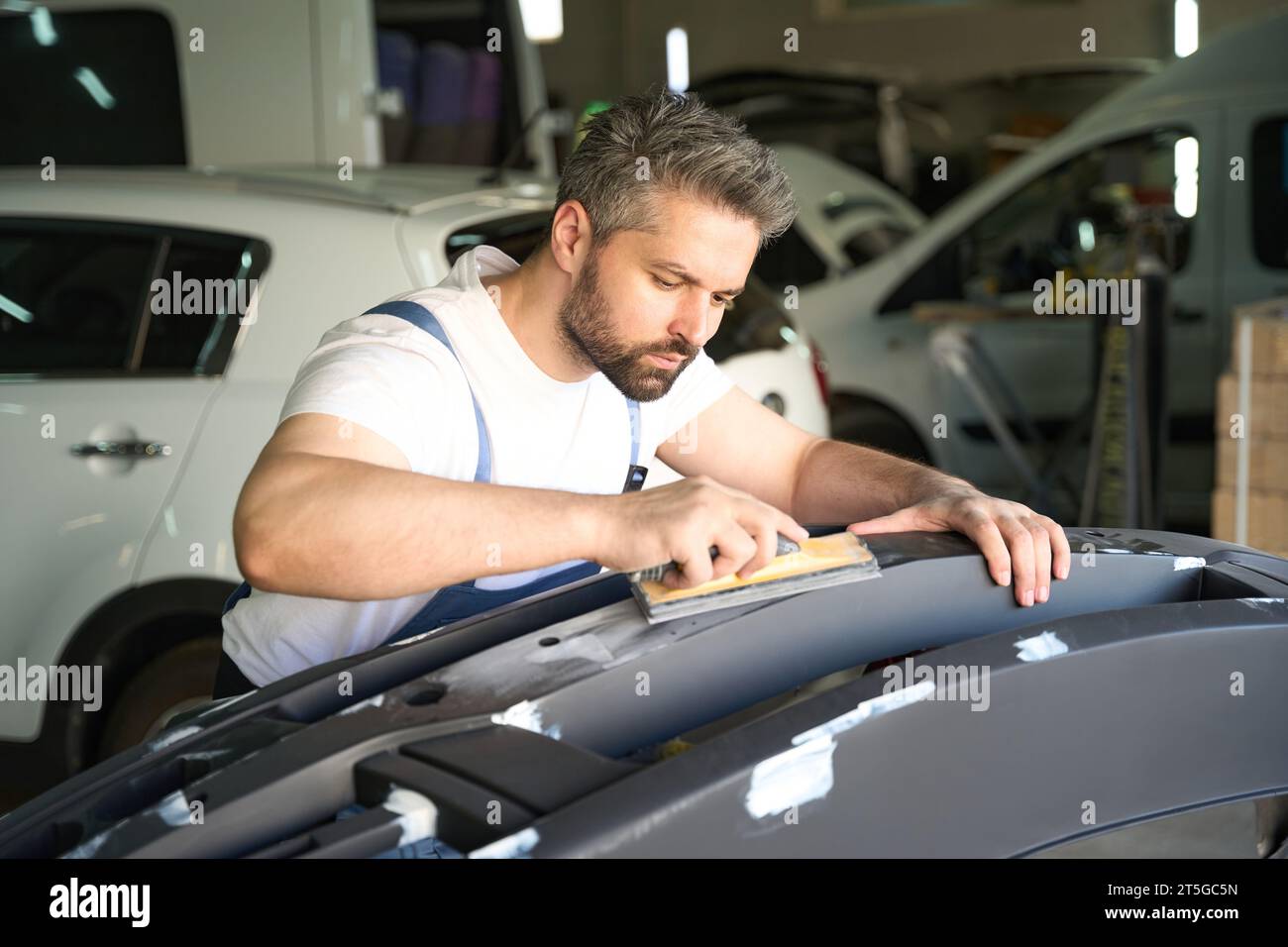 Experienced car detailer polishing automobile body part Stock Photo