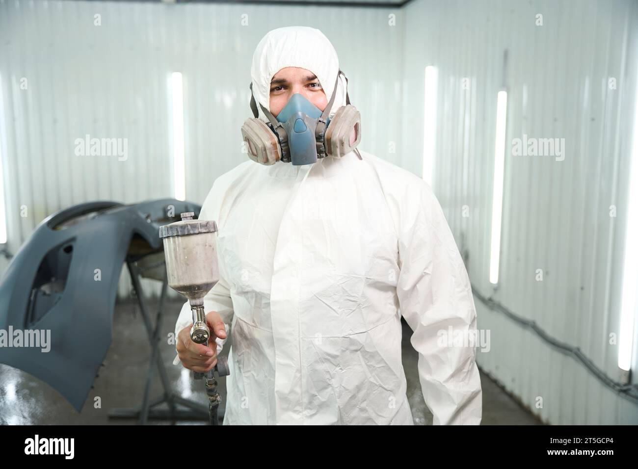 Pleased automotive repair shop worker after painting auto body panel Stock Photo