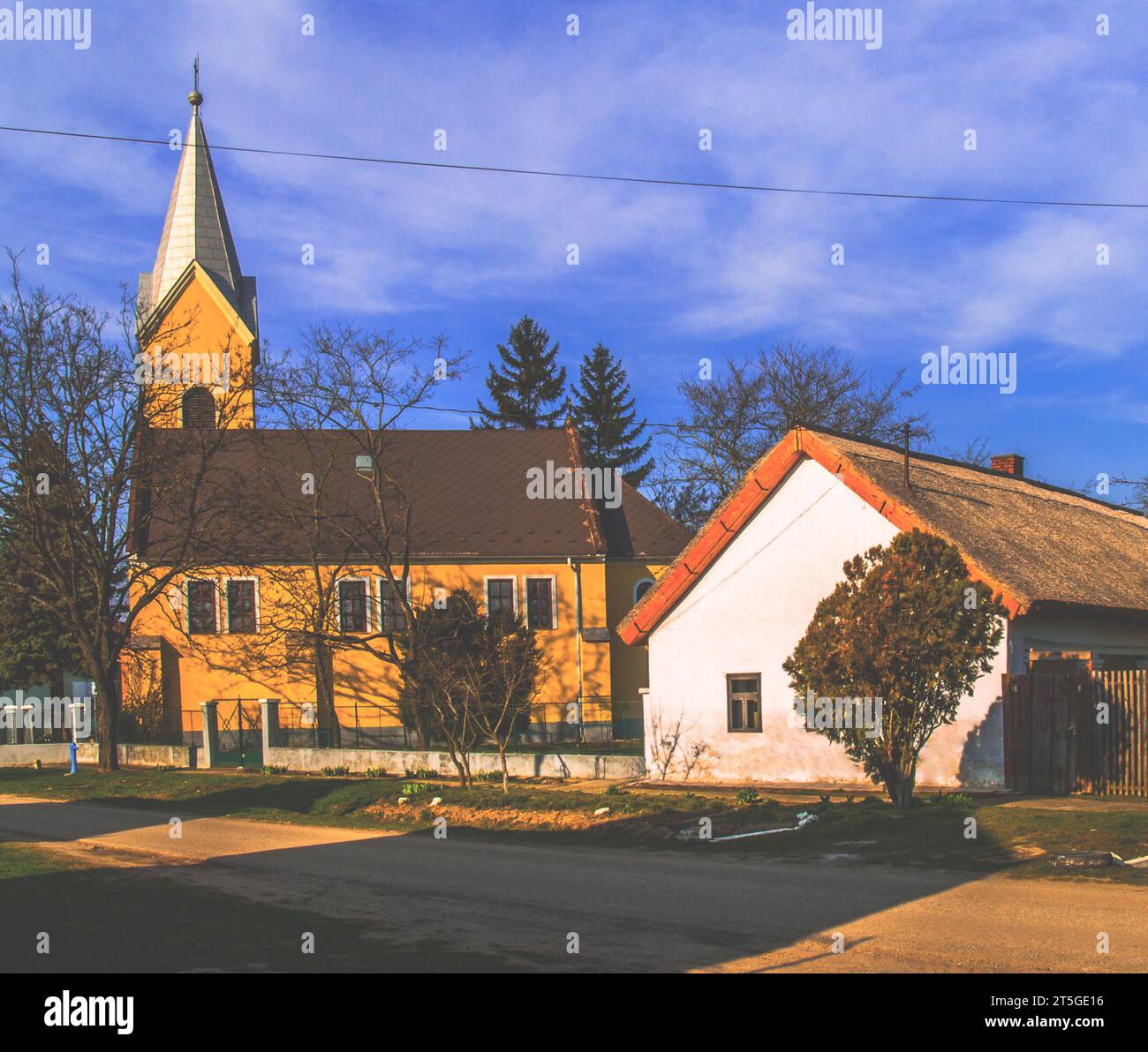 Small village church and small thatched house, idyllic village surroundings Stock Photo