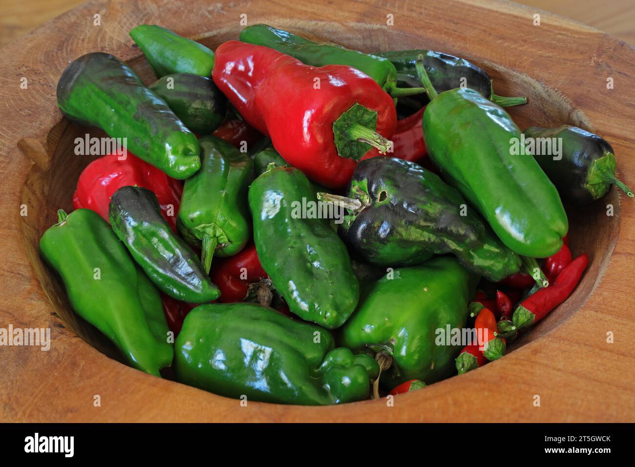 green and red pepper in a wooden bowl Stock Photo