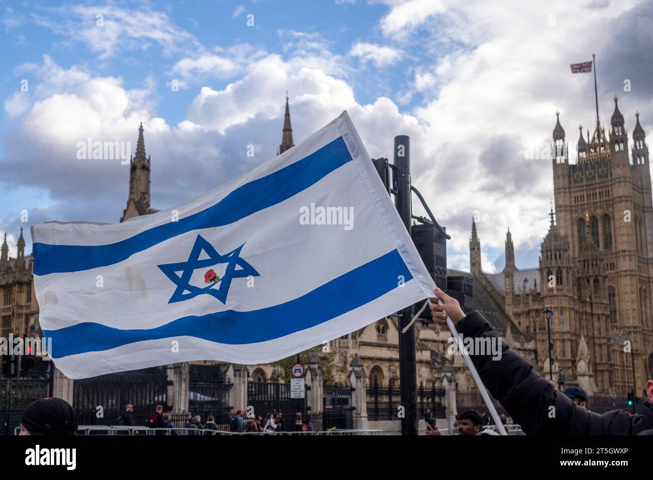 Parliament Square, Westminster, London, UK. 5th November 2023. Israeli's stand with the Israeli flag with Remembrance Red Poppy in centre, asking people to remember the 32 children and babies taken hostage by Hamas, and asking for peace. Credit: Rena Pearl/Alamy Live News Stock Photo