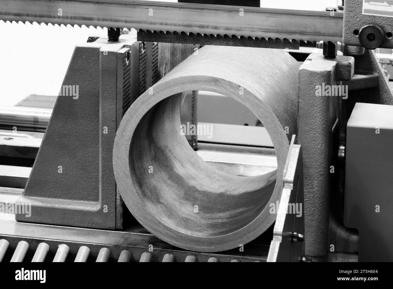 The automatic band saw machine cutting the metal bar with coolant