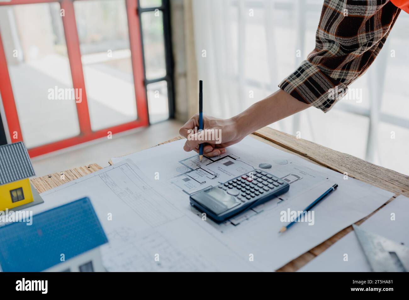 engineer brainstorming and measuring for cost estimating on blueprint and floor plan drawings