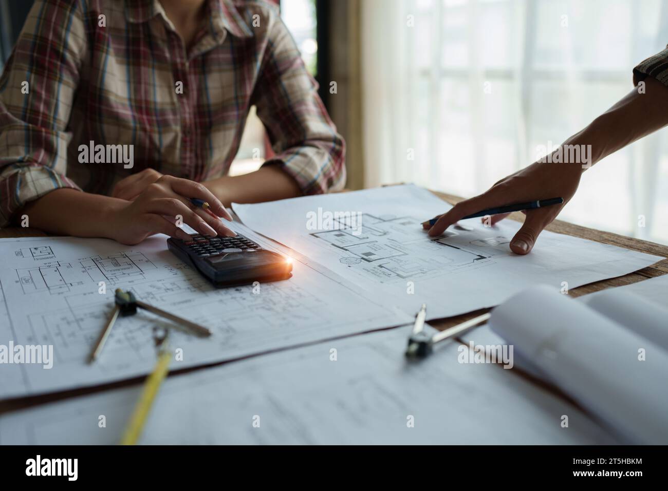 multi ethnic engineer brainstorming and measuring for cost estimating ...
