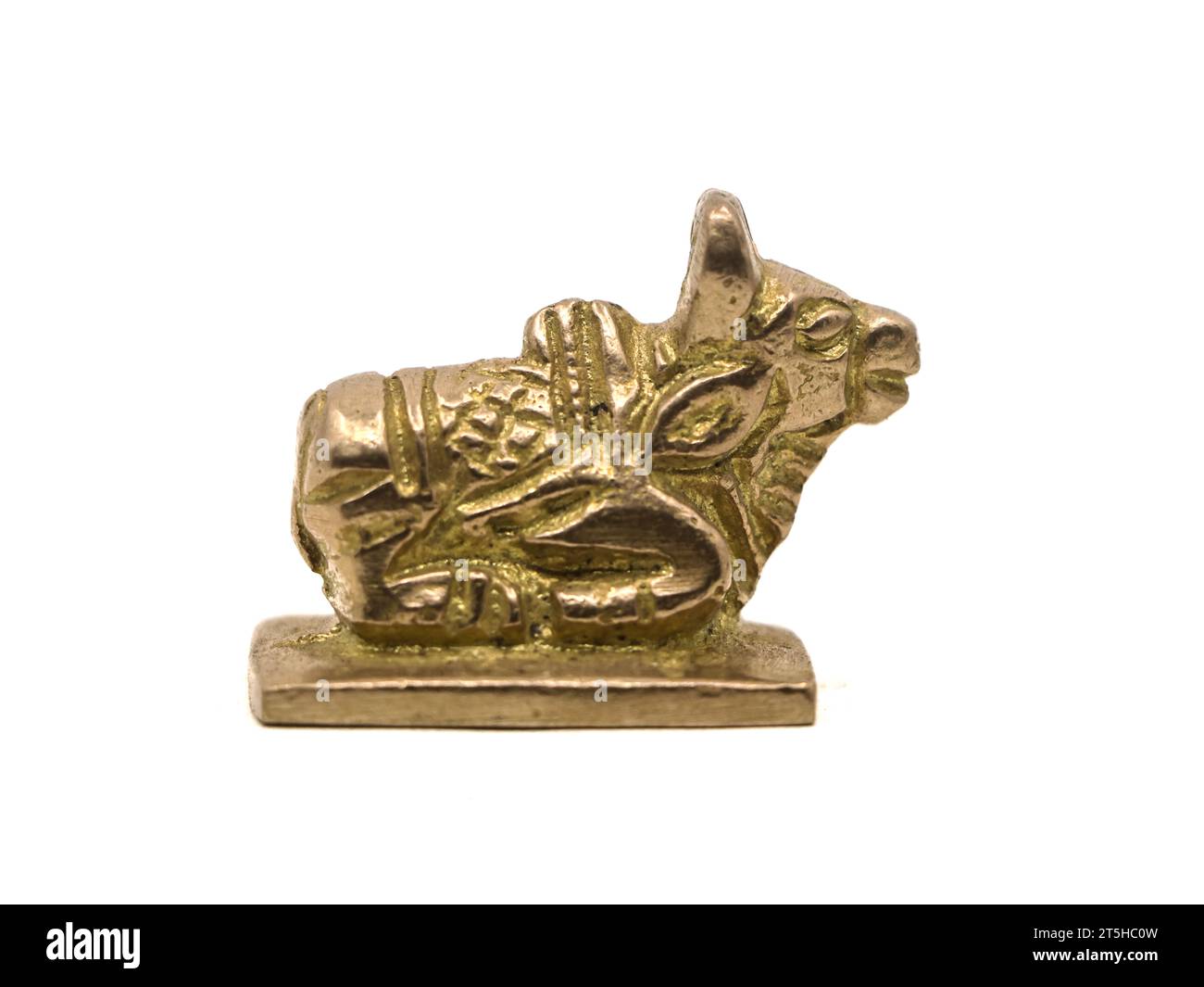 nandi cow of kailasa pet of lord shiva sitting statue crafted in gold, isolated in a white background Stock Photo