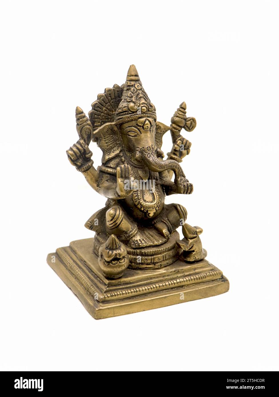 lord ganesh with four hands sitting brass statue with intricate details and decorative carvings isolated in a white background Stock Photo