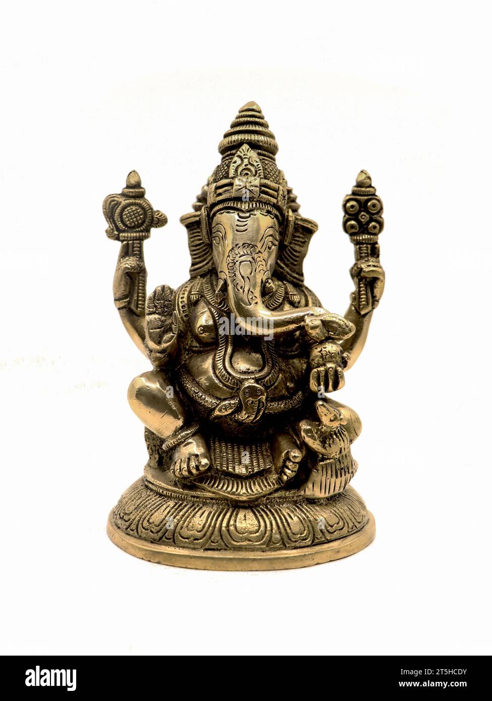 front view of sitting ganesh with four hands, brass statue with intricate details and decorative carvings isolated in a white background Stock Photo