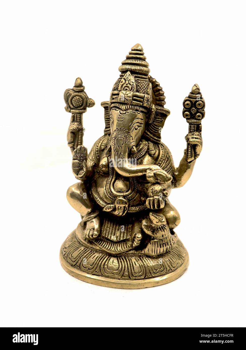 lord ganesh with four hands sitting brass statue with intricate details and decorative carvings isolated in a white background Stock Photo