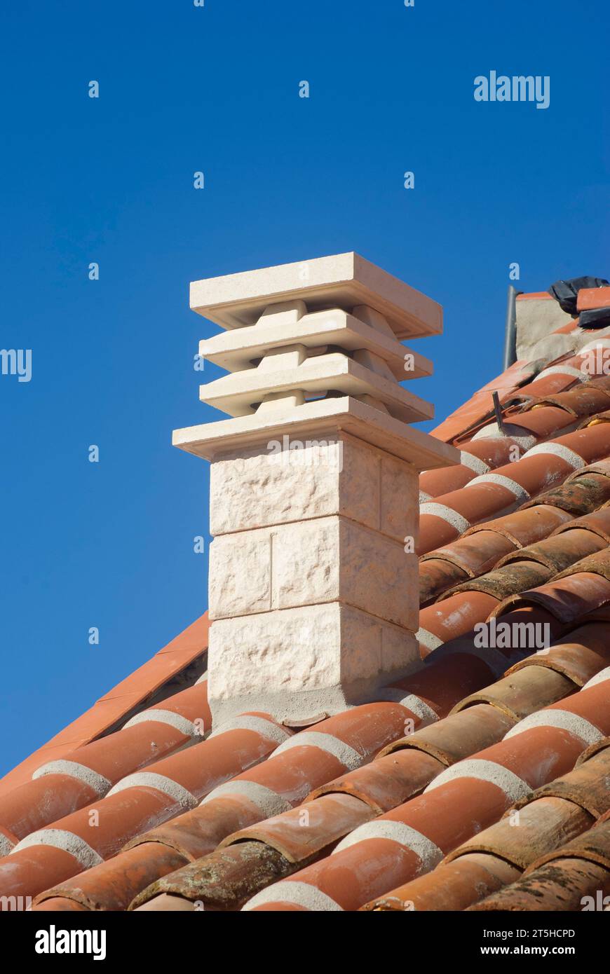 White chimney on tiled roof for smoke outlet with blue sky Stock Photo