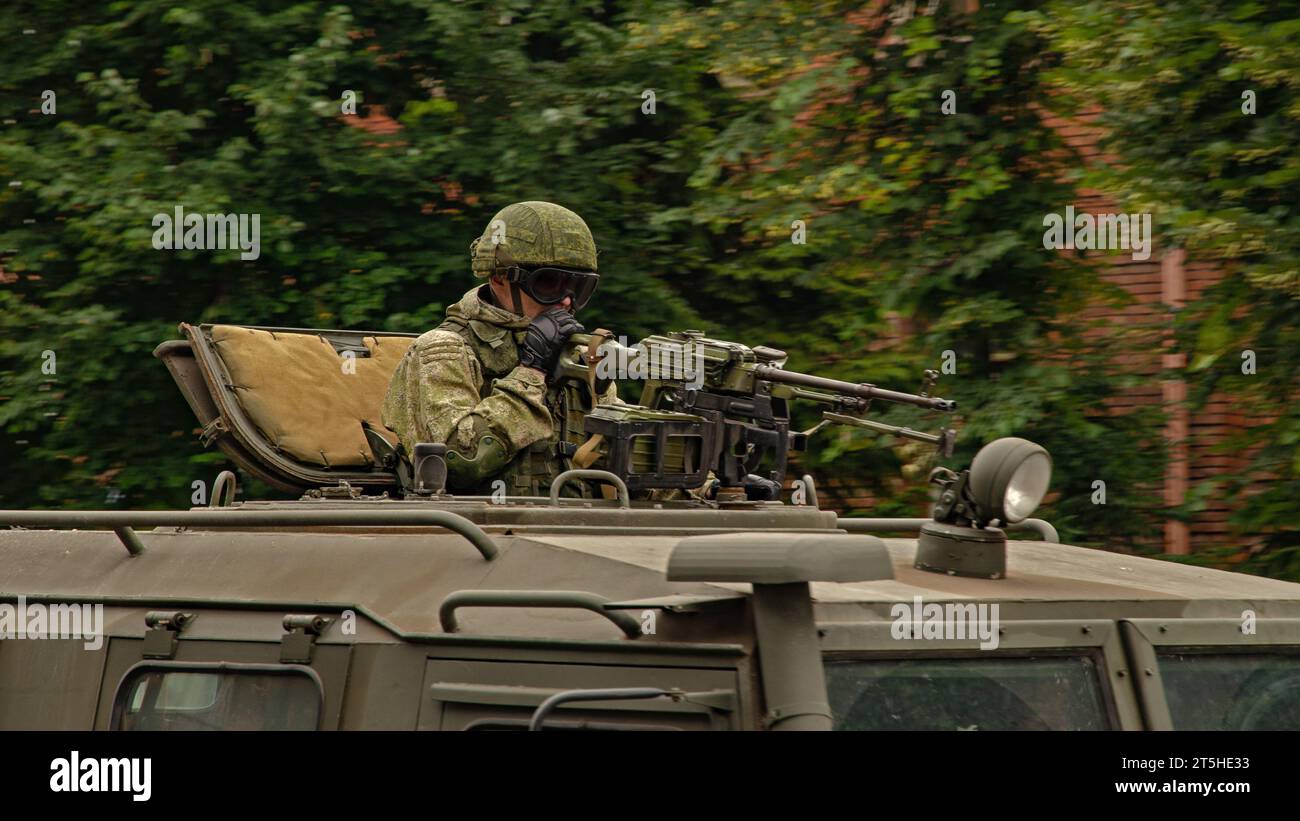 Russian machine-gun soldier in the hatch of an armored vehicle with full ammunition Stock Photo
