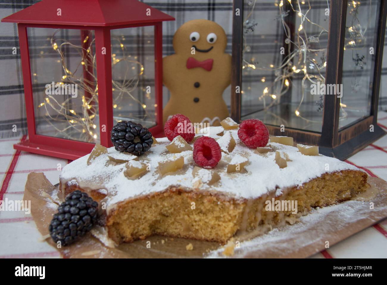 Happy gingerbread man surprised by finding a lovely cake Stock Photo