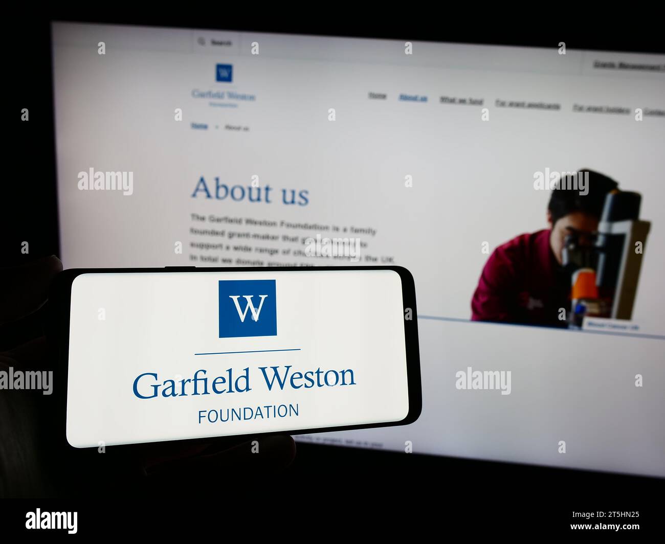 Person holding mobile phone with logo of British charitable