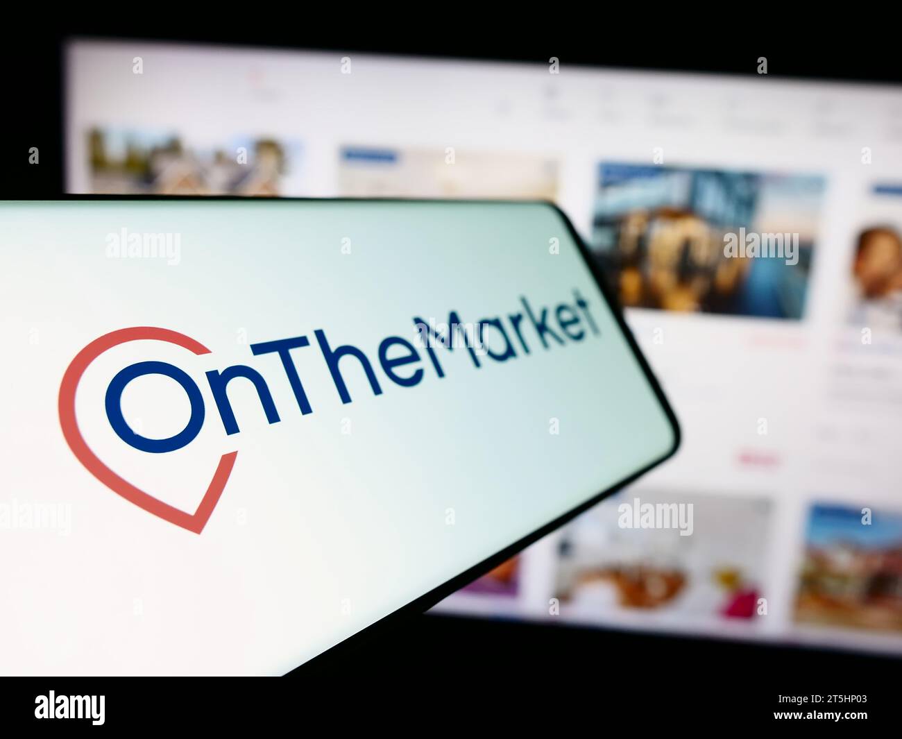 Smartphone with logo of British real estate portal company OnTheMarket.com in front of business website. Focus on left of phone display. Stock Photo