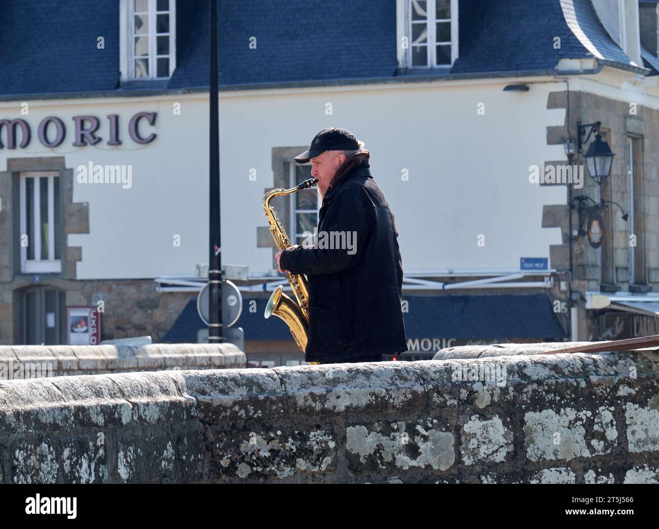 Man playing a saxophone on a bridge Stock Photo