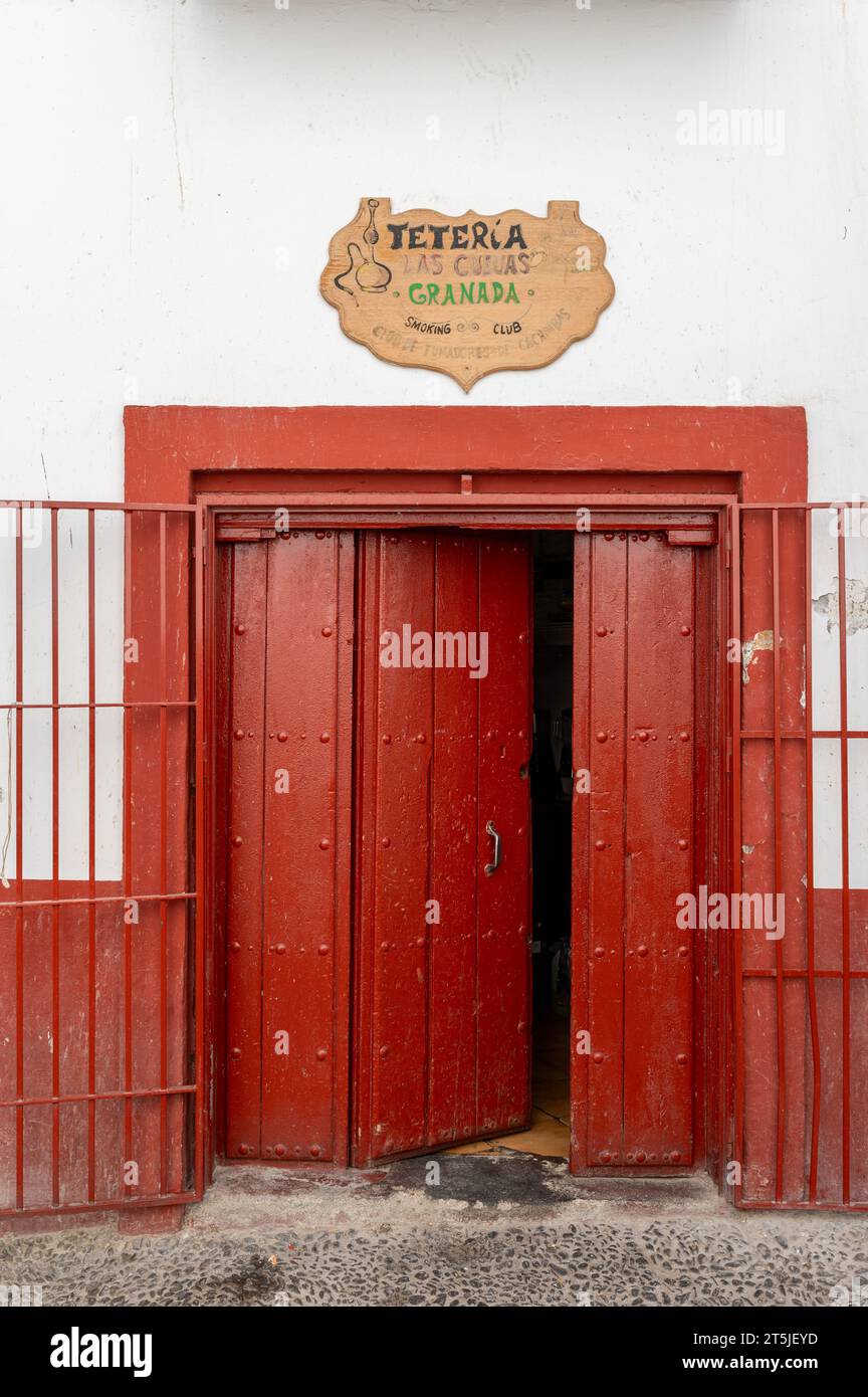 Granada, Spain; August-23, 2023: Half-open red wooden door of a Moorish tea shop on a street in Albaicin (Granada, Spain) Stock Photo