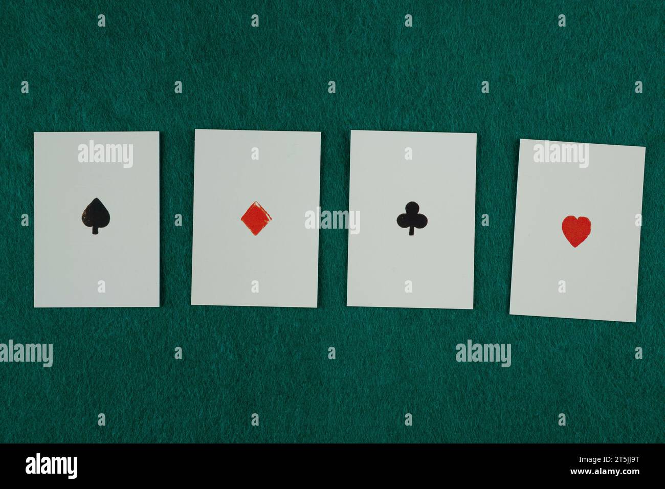 Old west era playing cards on green gambling table. Four of a kind, aces. Stock Photo