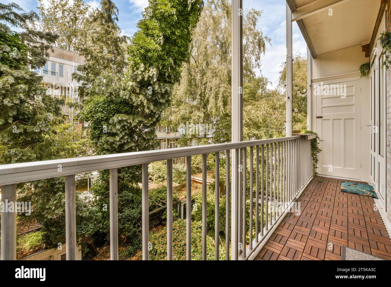 a balcony with trees in the background and a door to another room on
