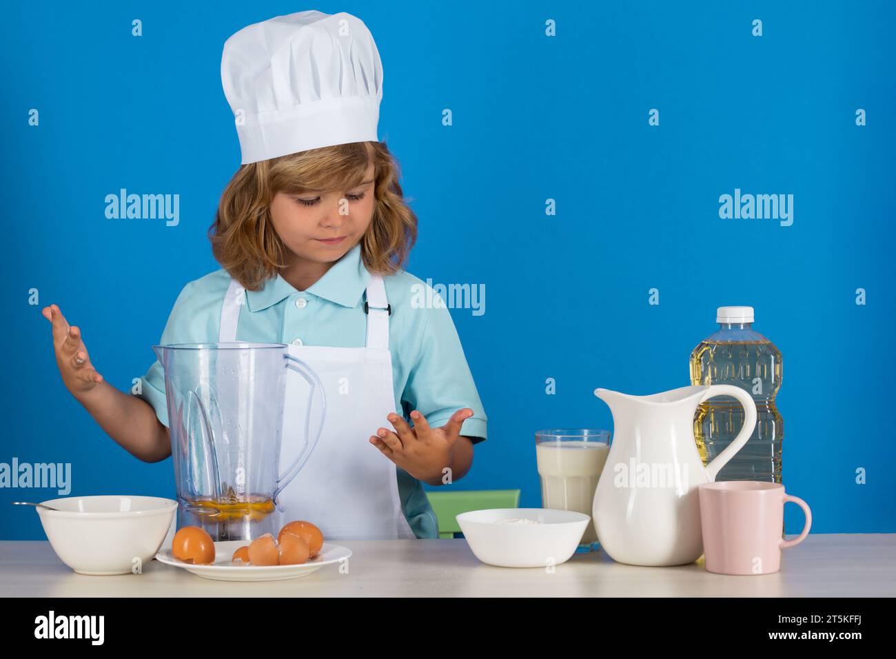 Portrait of a 7, 8 years old child in cook cap and apron making fruit