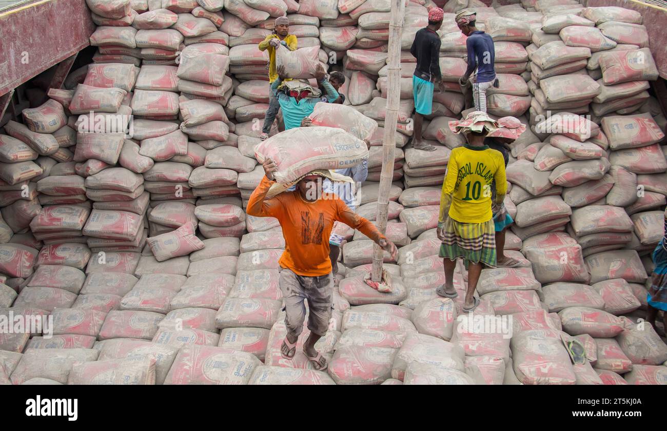Day laborer unloading cement from the boat, This image was captured on May 29, 2022, from Amen Bazar, Bangladesh Stock Photo