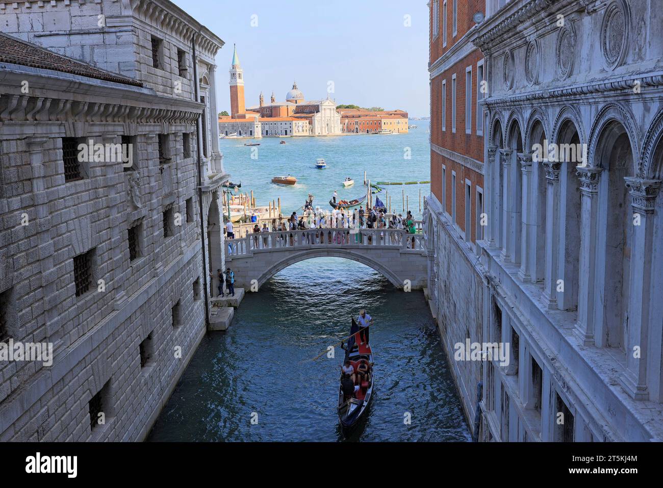 Tourists enjoying gondola ride and standing on the bridge, Dodge’s Palace area, Italy Stock Photo